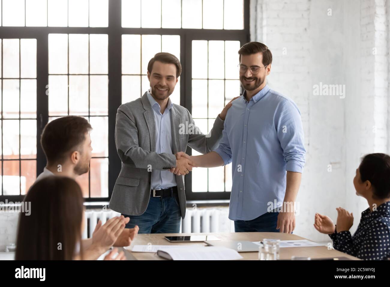Der Chef stellt den Mitarbeitern während der Einweisung in den Sitzungssaal einen neuen Mitarbeiter vor Stockfoto