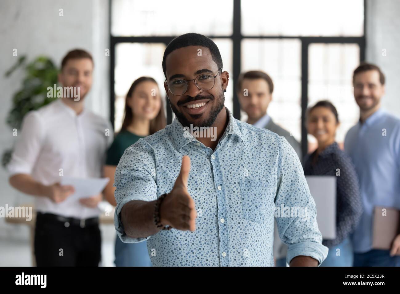 Der afrikanische Vertriebsleiter Stretch Out Hand stellt sich dem Kunden vor Stockfoto