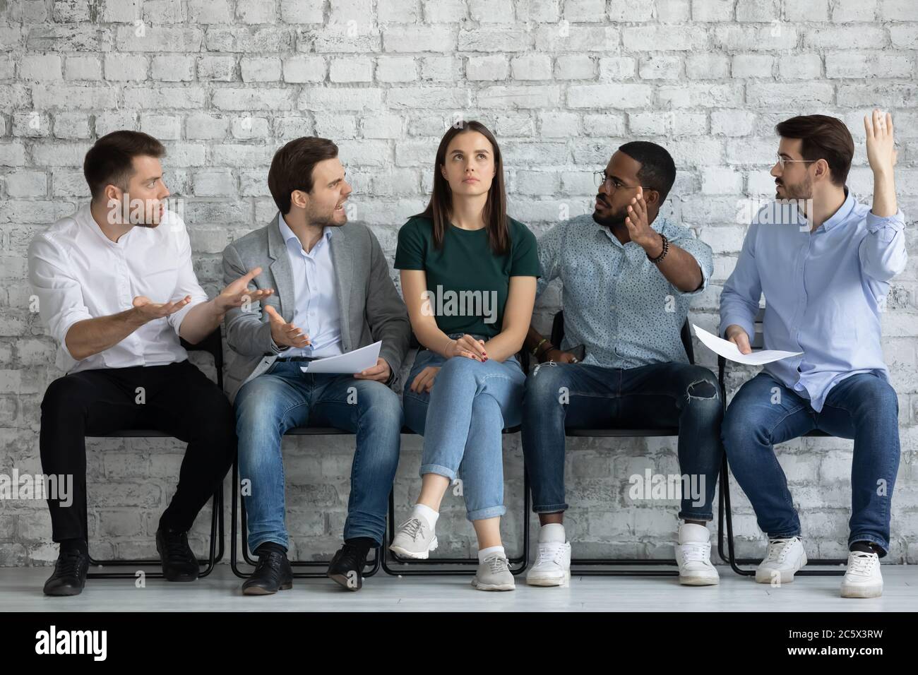 Männer Bewerber warten auf Job-Interview zeigen Respektlosigkeit für Mädchen Stockfoto