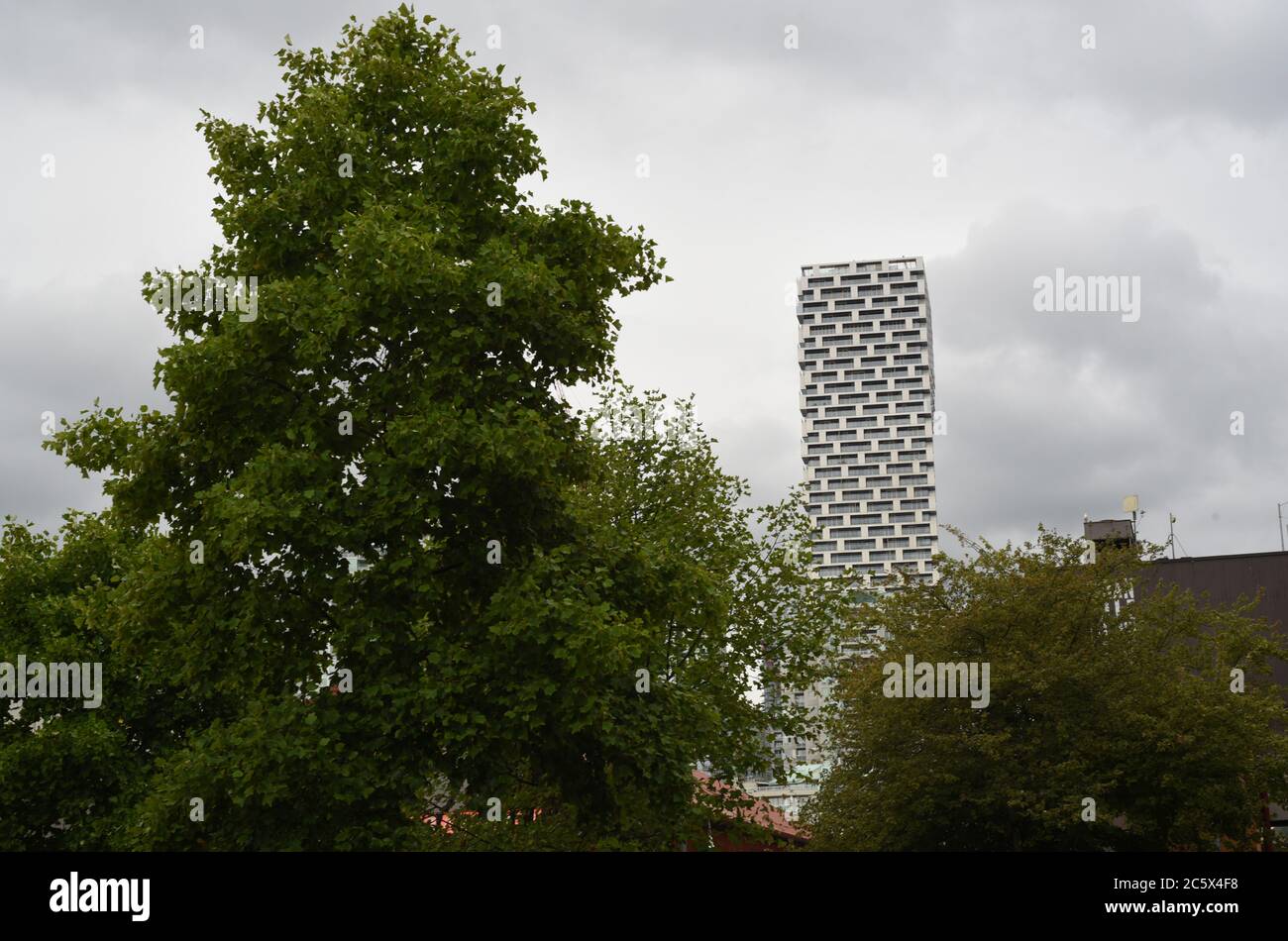 Der neue Wohnturm Vancouver House hebt sich vom Himmel über Bäumen in Vancouver, British Columbia, Kanada ab. Stockfoto