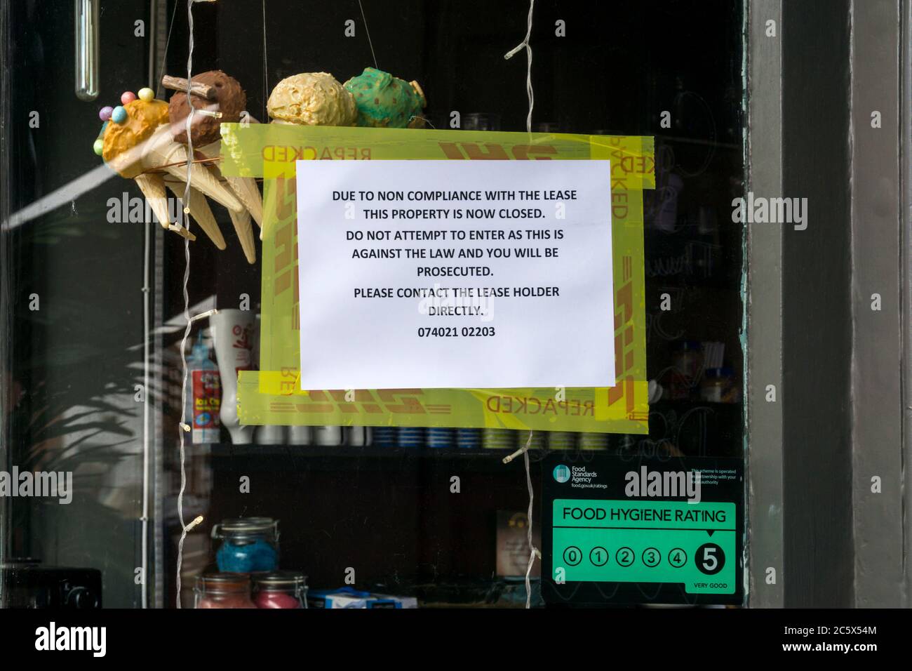 Ein Zeichen im Fenster eines Pachtladens, der für Nichteinhaltung des Mietvertrags wieder in Besitz genommen wurde. Stockfoto