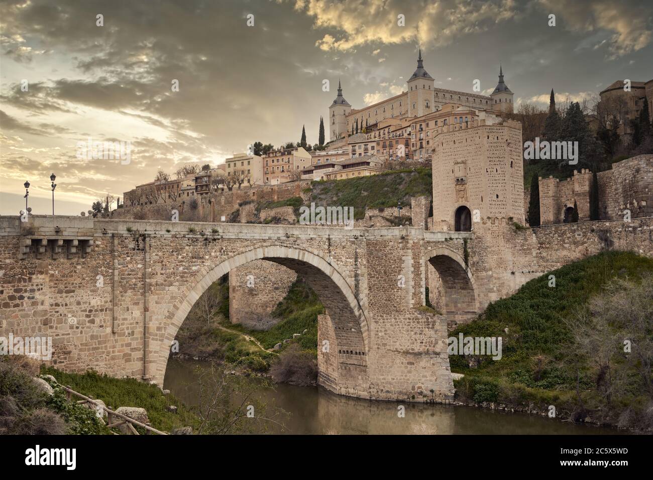 Toledo in Spanien mit dem Fluss Tejo und der römischen Brücke Puente de Alcantara. Berühmte UNESCO-Welterbestätte. Stockfoto
