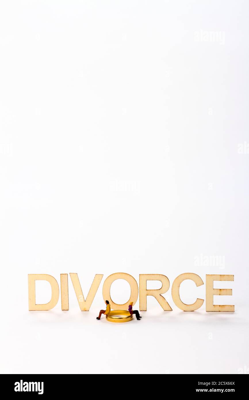 Scheidungsschild aus Holz mit Miniaturfigur Paar und einem Wedering Ring mit Kopierraum Stockfoto