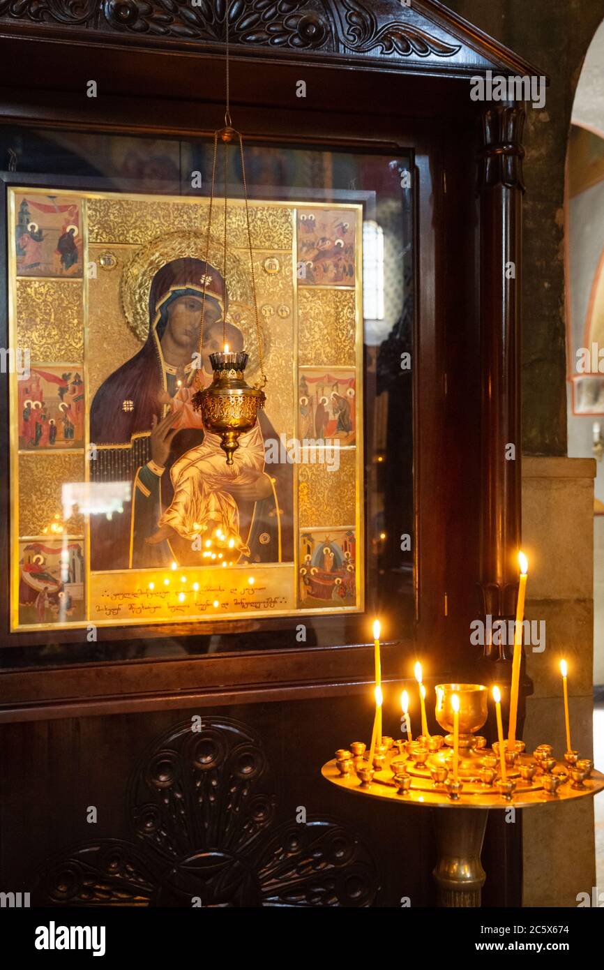 TIFLIS, GEORGIEN - 23. SEPTEMBER 2018: Wachskerzen brennen in einem Kerzenständer vor der orthodoxen Ikone der Gottesmutter in der Kathedrale von Sioni Stockfoto