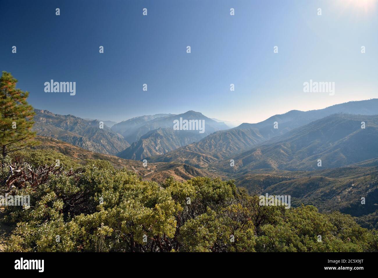 Der Blick vom Highway 180, der separate Teile des Kings Canyon National Park verbindet. Leichter Dunst über den Bergen und blauer Himmel. Kalifornien. Stockfoto