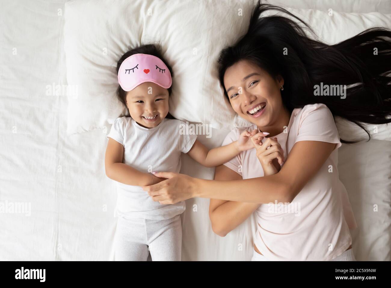 Lächelnd ziemlich asiatische Kind Spaß mit Mama in Morgen. Stockfoto
