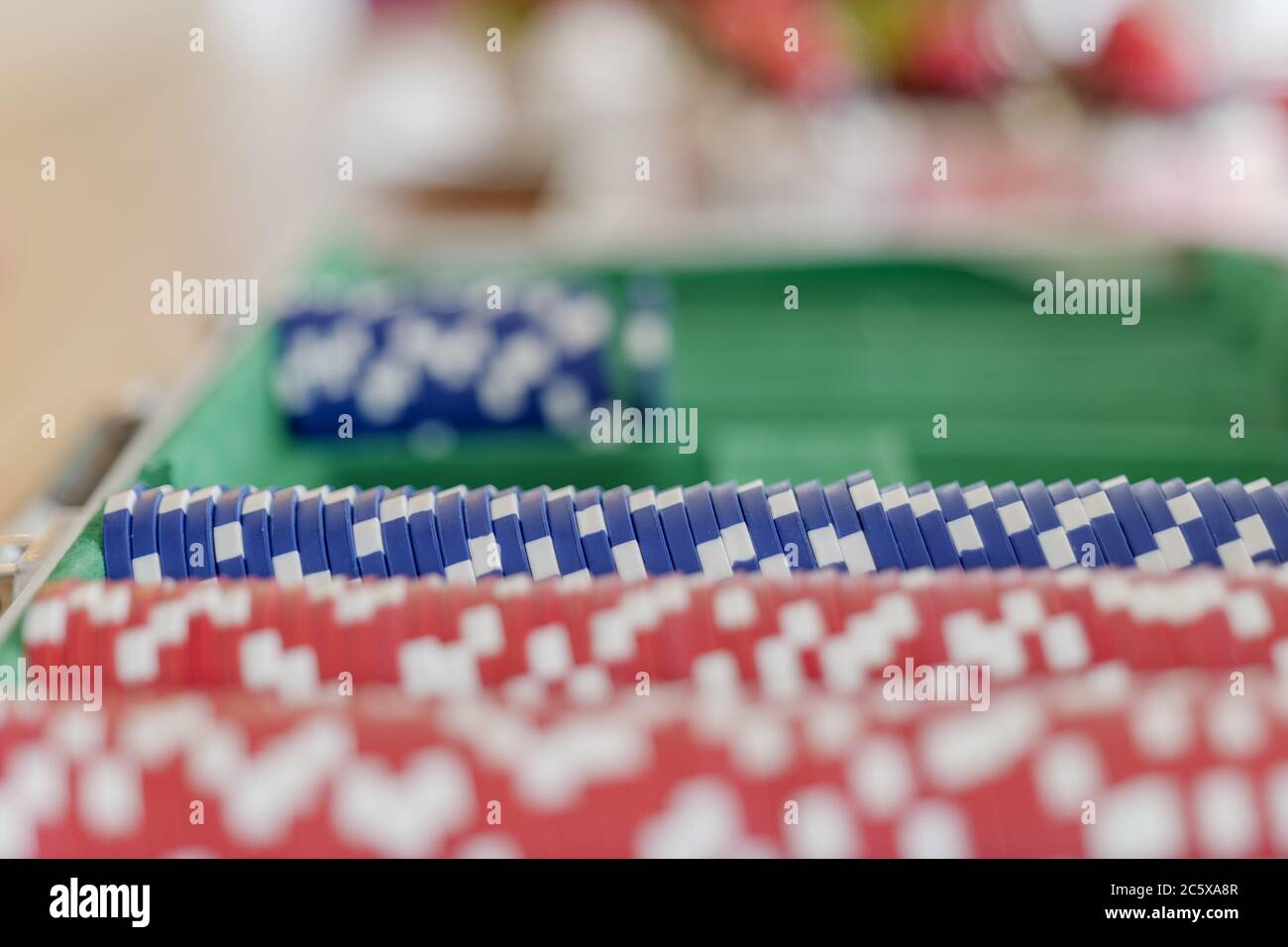 Ausgewählte Fokus auf Reihen von blauen Kunststoff-Poker-Chips in der Poker-Box auf Holztisch und Defokussieren Hintergrund der roten gesetzt. Stockfoto