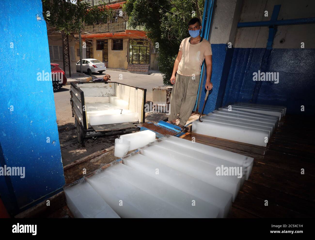 Bagdad. Juli 2020. Ein Mann arbeitet am 5. Juli 2020 in einer Eiswerkstatt in Bagdad, Irak. Da sich die Temperatur in Bagdad um 50 Grad Celsius nähert, gedeiht die Eisherstellung hier mit der steigenden Nachfrage nach Eisblöcken. Quelle: Xinhua/Alamy Live News Stockfoto