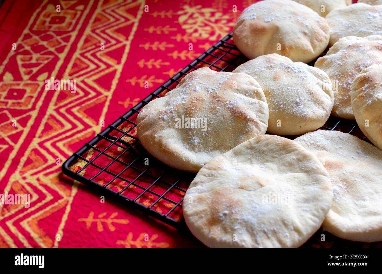 Pita Brot, Focaccias, Ciabatta mit Mehl Mantel über kühlenden Lappen mit roten und orangen Hintergrund Stockfoto