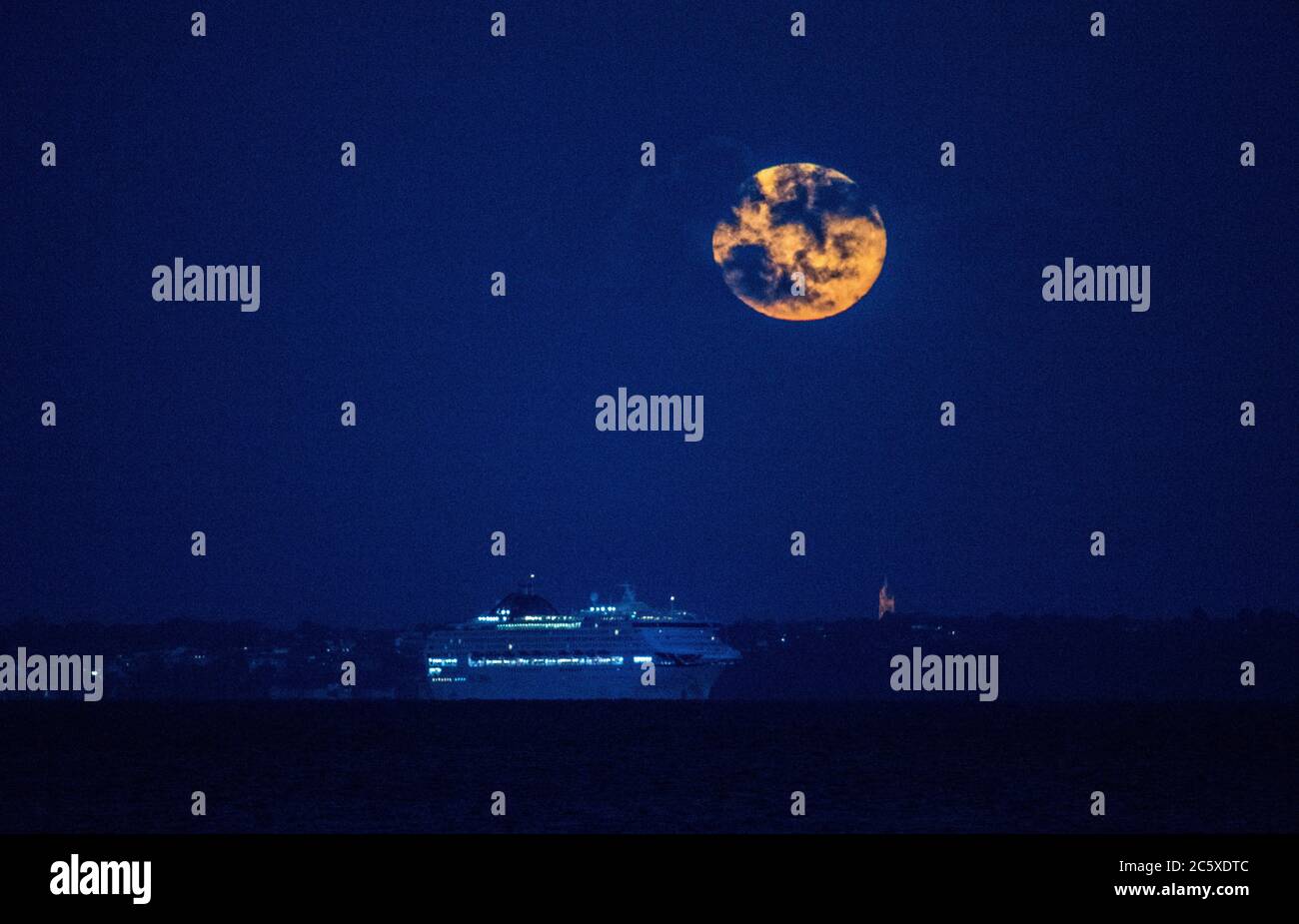 Isle of Wight. Juli 2020. Wetter in Großbritannien. Der Vollmond, bekannt als Buck Moon oder Thunder Moon, steigt hinter dem Kreuzfahrtschiff Oceana auf der Solent mit der Isle of Wight im Hintergrund auf. Credit Stuart Martin/Alamy Live News Stockfoto