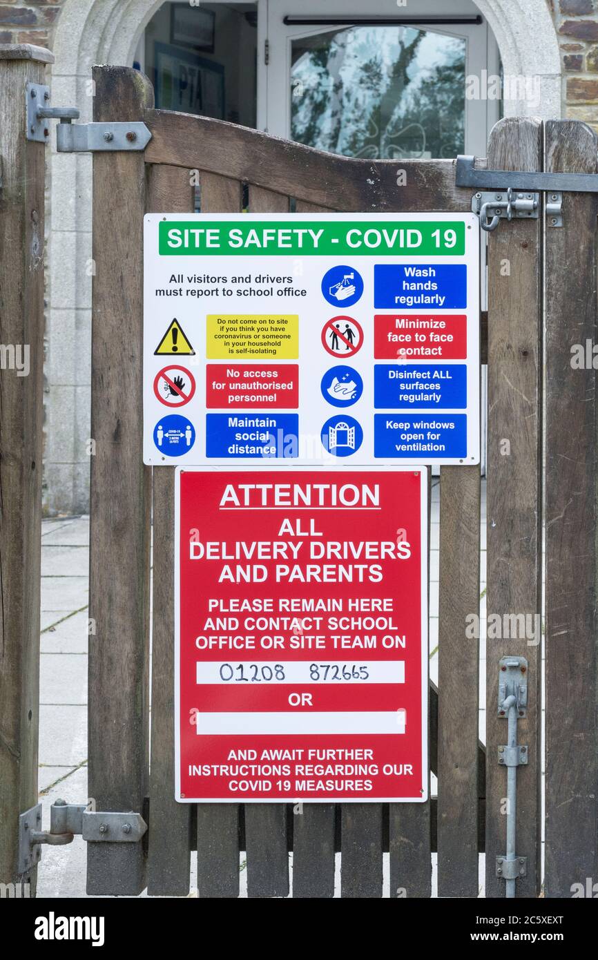 CV19, Covid-19 Schule Sicherheitsmassnahmen Warnschild & Warnpiktogramme am Tor der St. winnow Primary School, Lostwithiel, Cornwall. Stockfoto