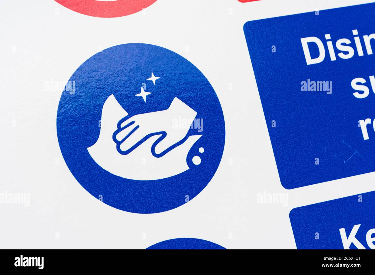 Covid-19 Schule Sicherheitsmassnahmen Warnschild & Warnpiktogramme. Am Tor der St. winnow Grundschule, Lostwihiel. Piktogramm Oberflächen desinfizieren Stockfoto