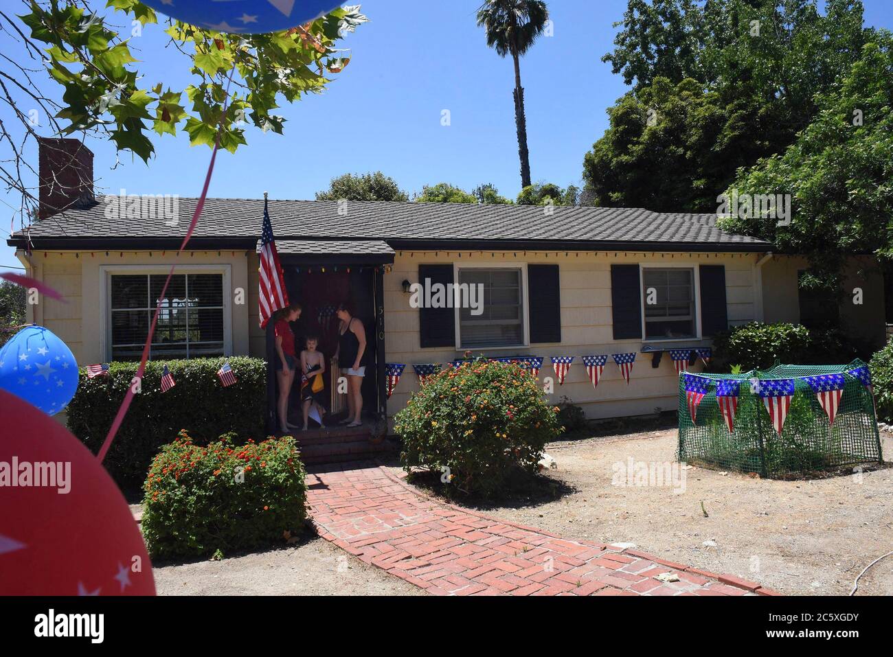 Sierra Madre, Kalifornien, USA. Juli 2020. Naomi Smoron (ganz rechts) Ihre Tochter Naomi Simoron und ihr Sohn Merek Smoron (Mitte) kommen sehr hoffnungsvoll vor die Tür, dass ihr Haus den ersten Platz gewinnt, während es vom städtischen Dekorationskomitee beurteilt wird.Quelle: Catherine Bauknight/ZUMA Wire/Alamy Live News Stockfoto Sierra Madre, Kalifornien, USA. Juli 2020. Naomi Smoron (ganz rechts) Ihre Tochter Naomi Simoron und ihr Sohn Merek Smoron (Mitte) kommen sehr hoffnungsvoll vor die Tür, dass ihr Haus den ersten Platz gewinnt, während es vom städtischen Dekorationskomitee beurteilt wird.Quelle: Catherine Bauknight/ZUMA Wire/Alamy Live News Stockfoto