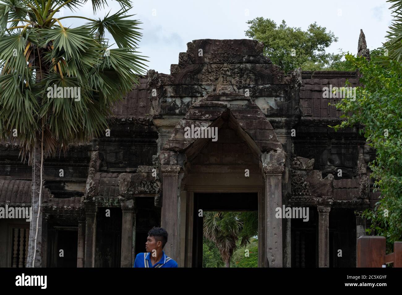 Angkor Wat Flachrelief, Innenhof mit üppiger Vegetation und ein khmer Mann. Siem Reap, Kambodscha. Stockfoto