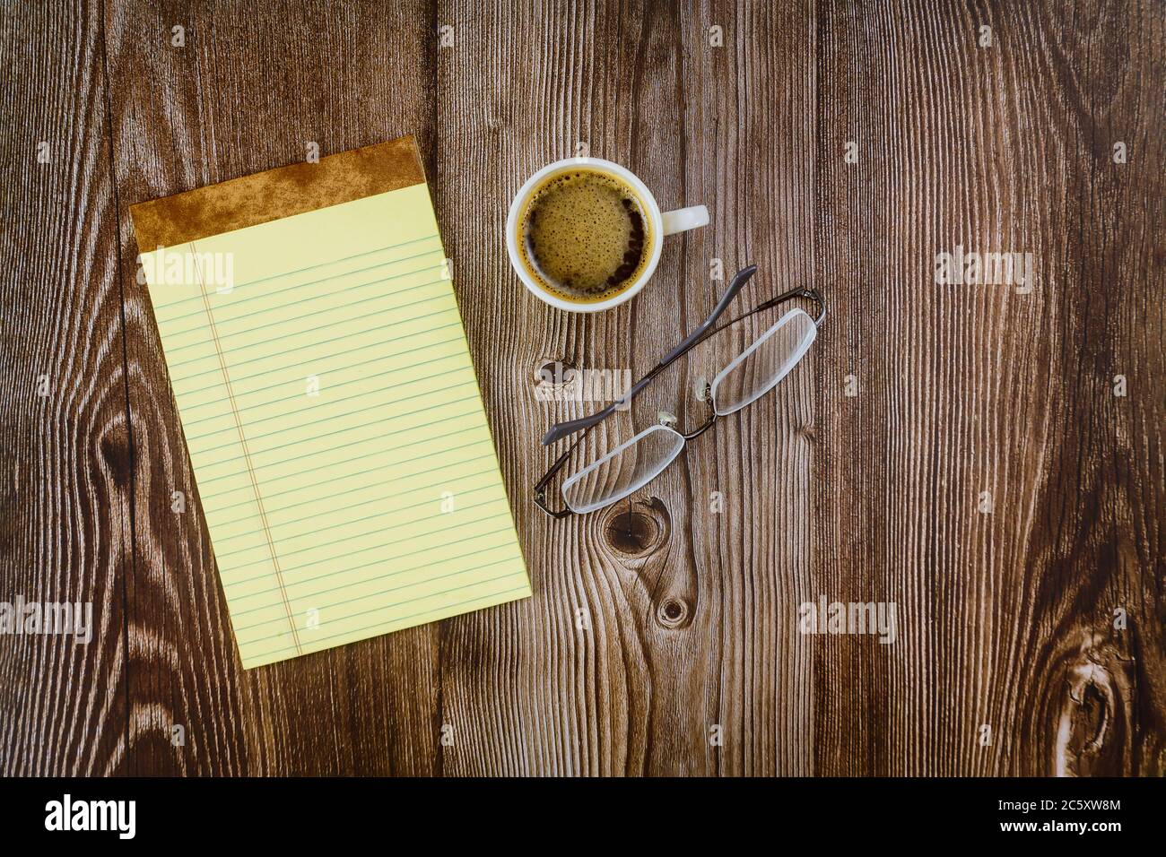 Bürobedarf mit Notebook-Brille und Espresso-Kaffee auf Holztisch Stockfoto