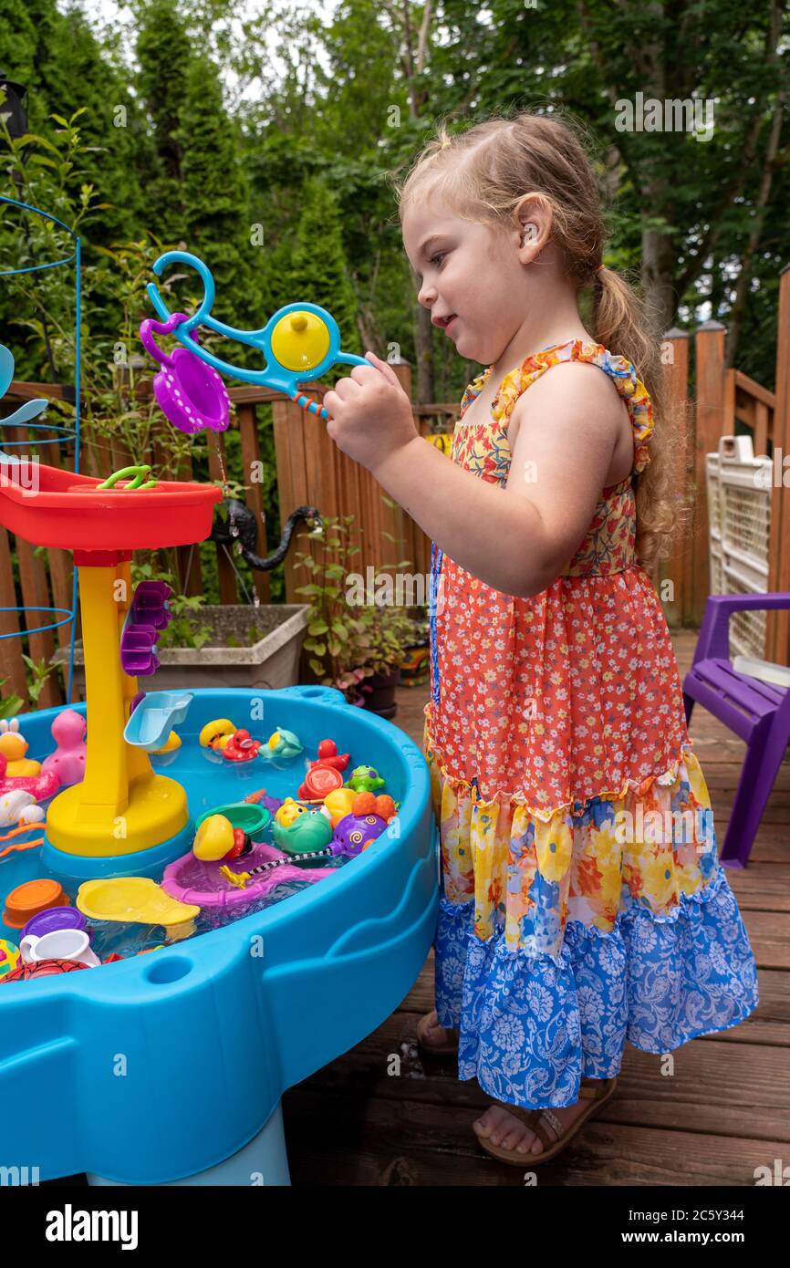 Drei Jahre altes Mädchen mit Spaß mit ihr außerhalb Wasser Spielzeug. Sie hat ein Spielzeug mit ihrer Angel 'Rute' gefangen. Stockfoto