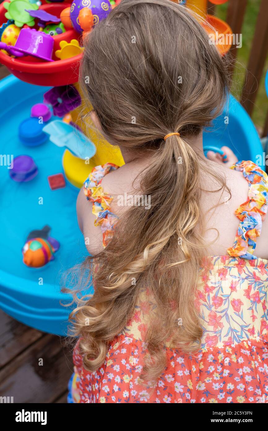 Drei Jahre altes Mädchen mit Spaß mit ihr außerhalb Wasser Spielzeug. Ihr Haar wird so lang! Stockfoto