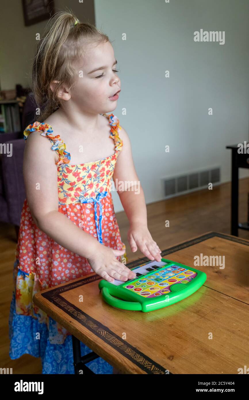 Drei Jahre alt Spaß spielen draußen vorgeben, große Emotion zu zeigen, während sie spielt ihr Spielzeug Klavier Stockfoto