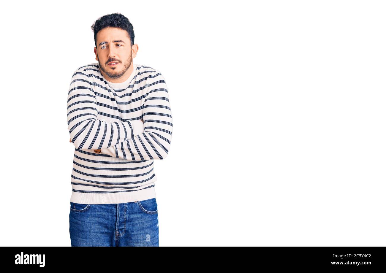 Junger hispanischer Mann trägt lässige Kleidung, die für Winterkälte zittert und friert, mit trauriger und schockierender Gesichtsausdruck Stockfoto
