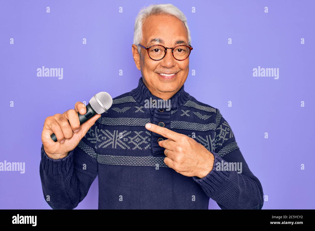 Alter Senior grauhaarige Sänger Mann singen mit Musik Mikrofon über lila  Hintergrund sehr glücklich zeigen mit Hand und Finger Stockfotografie -  Alamy
