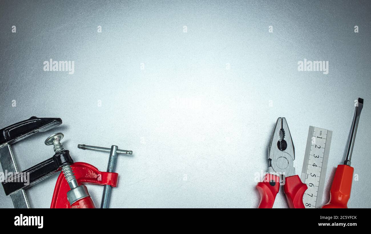 Set von verschiedenen Handarbeitswerkzeugen auf grauem, zerkratztem Metallhintergrund, Draufsicht Stockfoto