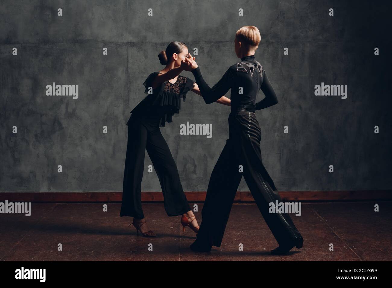 Paar in schwarzen Kostümen tanzen im Ballsaal Rumba Tanz Stockfoto