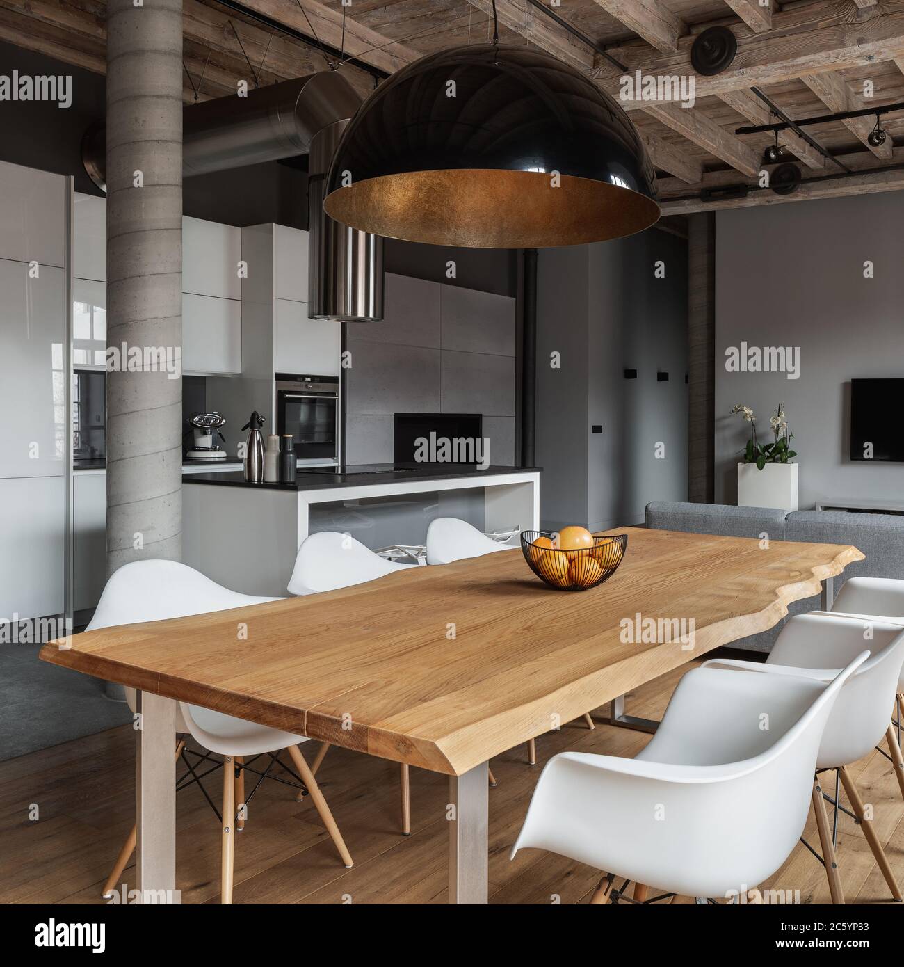 Industrial Home Interieur mit langem Esstisch und Holzdecke und schwarze Pendelleuchte Stockfoto