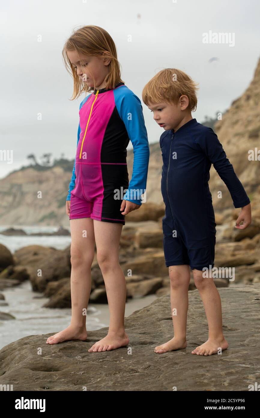 Zwei Kinder, ein kleiner Junge und ein Mädchen, die am Sandstrand spielen Stockfoto