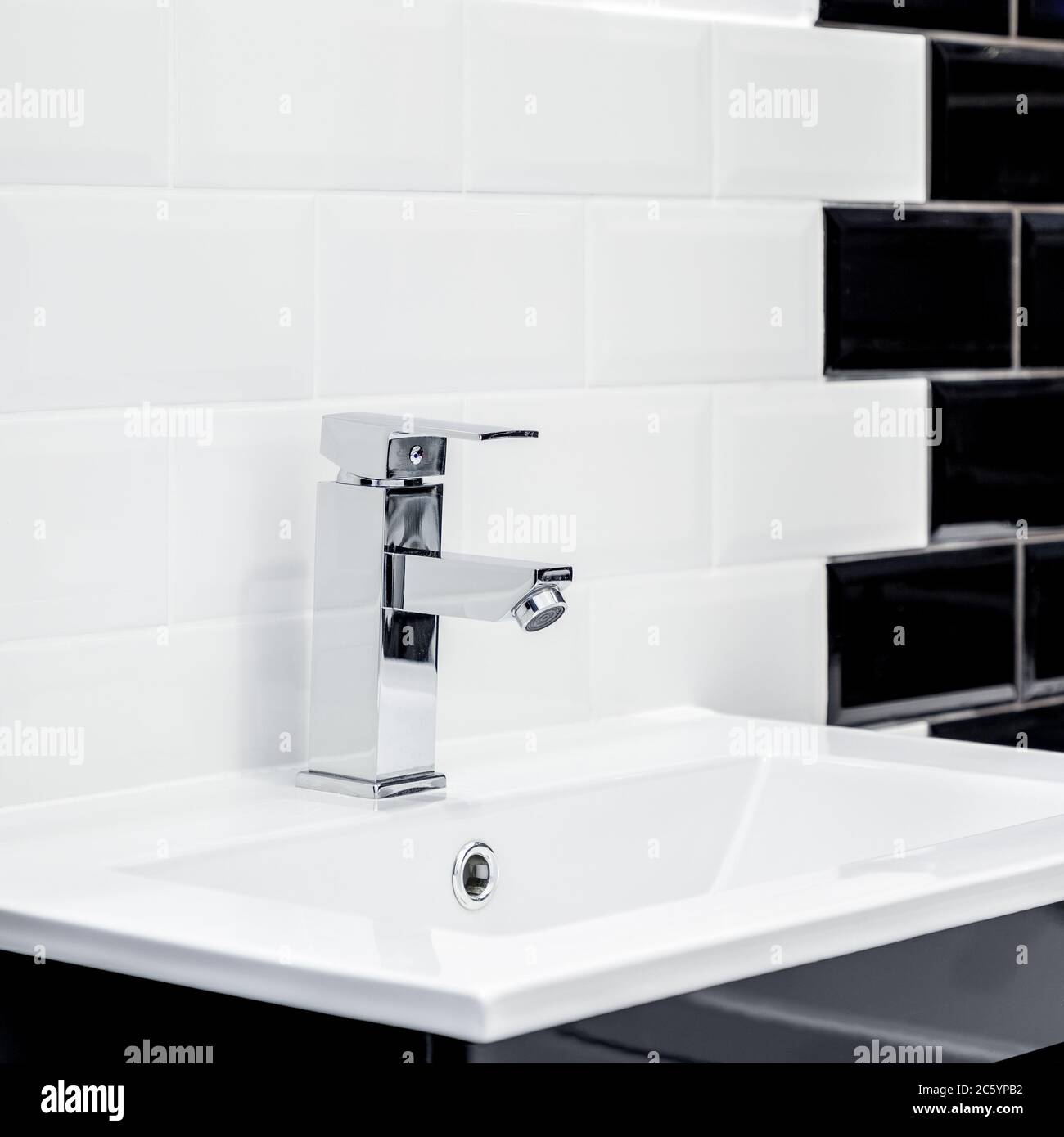 Kleines Waschbecken im Badezimmer und moderne Ziegelsteine in schwarz und weiß Stockfoto