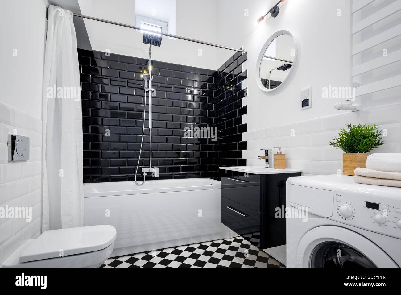 Schwarze und weiße Bad mit Badewanne, Wc und Waschmaschine Stockfoto
