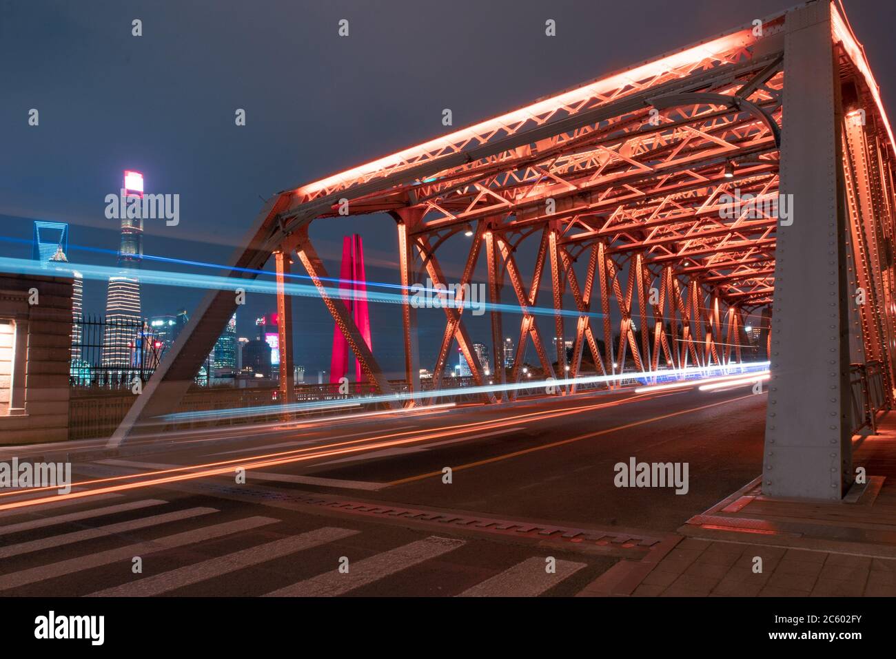 Nachtansicht der Waibaidu Bridge, einer der Wahrzeichen von Shanghai, mit Verkehr und modernen Wolkenkratzern im Hintergrund. Stockfoto