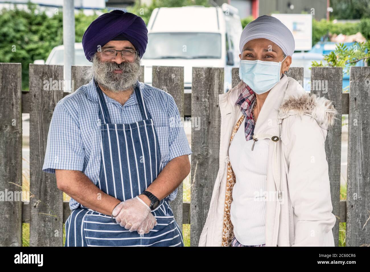 Khesh und Kuwant Sidhu auf ihrem Stand auf dem lokalen Lebensmittelmarkt in Presteigne, Wales, Großbritannien, der gerade nach monatelanger Sperre wieder eröffnet wurde Stockfoto