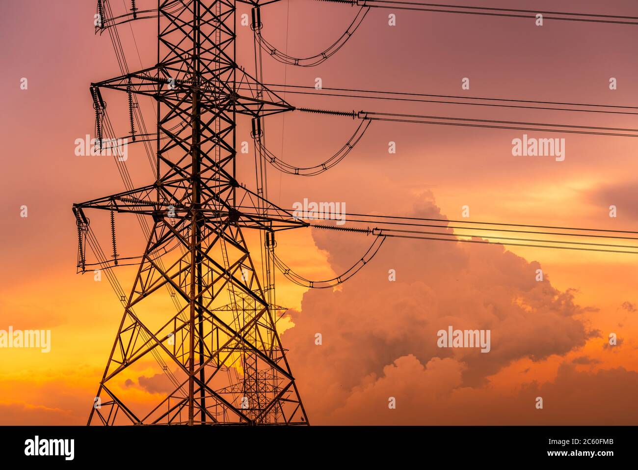 Hochspannungs-elektrischer Pylon und elektrische Leitung mit Sonnenuntergang Himmel. Strommast. Energie- und Energiekonzept. Hochspannungs-Netzturm mit Drahtkabel. Stockfoto