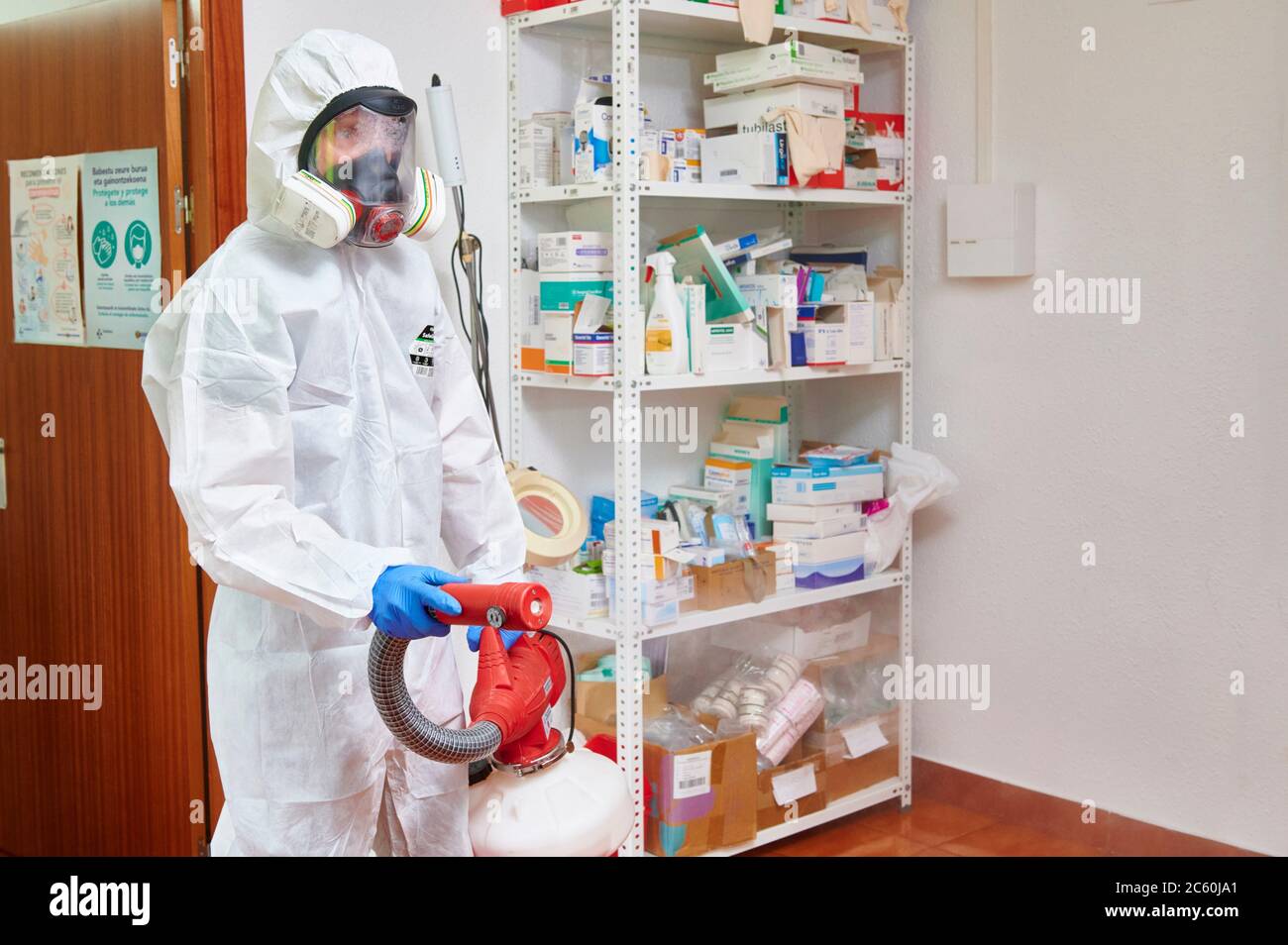 Techniker, der das medizinische Zentrum mit chemischen Reinigungsmitteln gegen Covid-19 desinfiziert. Stockfoto