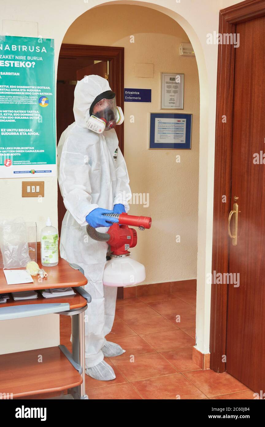 Techniker, der das medizinische Zentrum mit chemischen Reinigungsmitteln gegen Covid-19 desinfiziert. Stockfoto