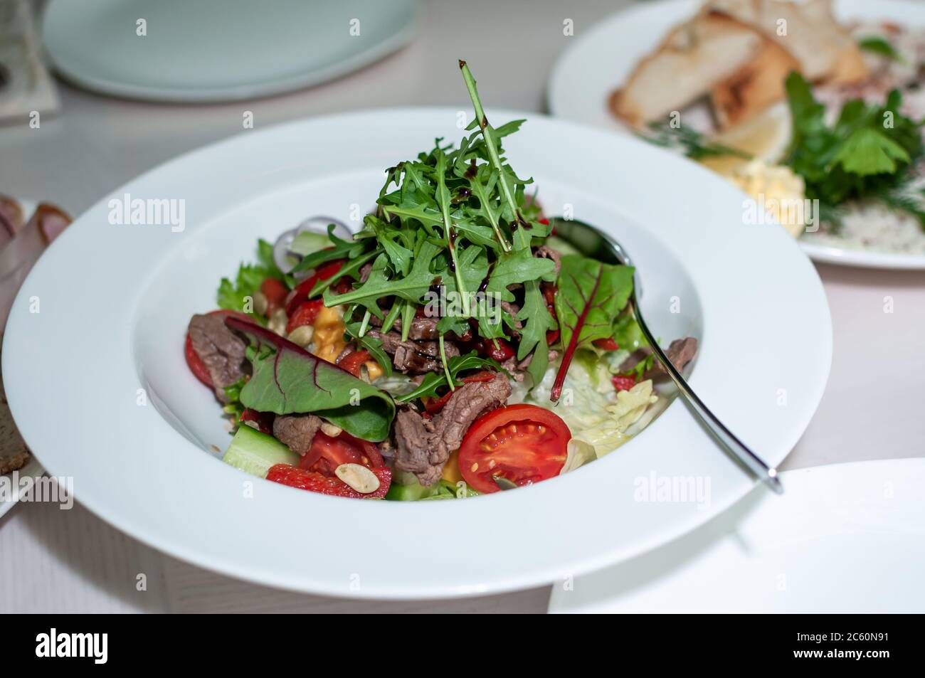 Salat mit kastanischem Rinderkirsche auf einem weißen Teller Stockfoto