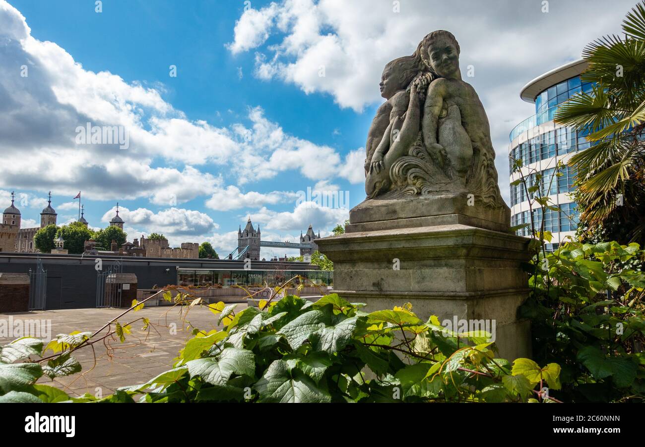 Der Kirchhof von All Halloows by the Tower mit einer Wasserskulptur von Meerjungfrauen und Delfinen, gestaltet von Cecil Thomas im Vordergrund. Stockfoto