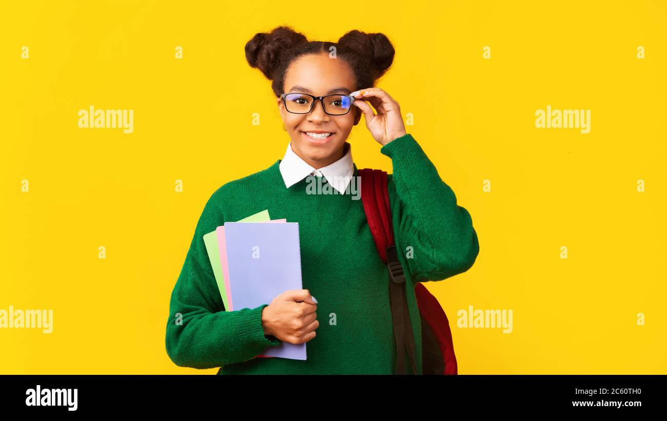 Schöne schwarze Teenager-Mädchen mit bunten Notebooks Stockfoto
