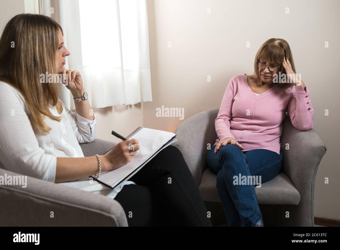 Psychologe in seinem Büro, der einen Patienten betreut und Notiz nimmt. Stockfoto