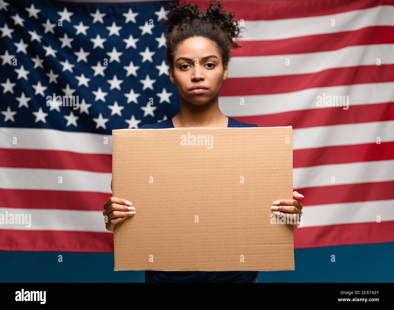 Schwarze Frau mit leerem Plakat, amerikanische Flagge Stockfoto