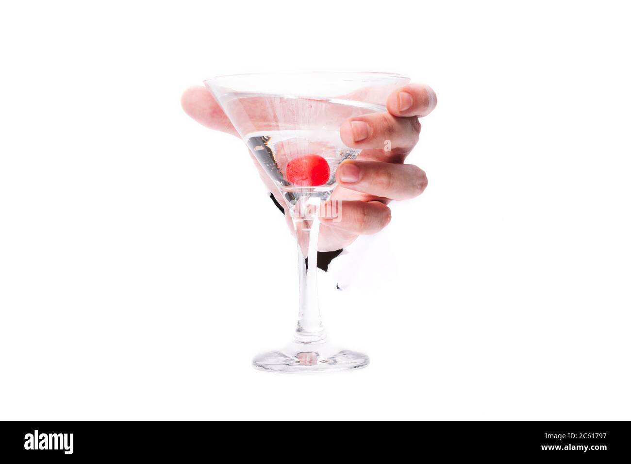 Männliche Hand mit einem Glas Martinok mit einer roten Beere durch ein Loch in Papier auf weißem Hintergrund isolieren. Nahaufnahme, kopieren Raum. Stockfoto