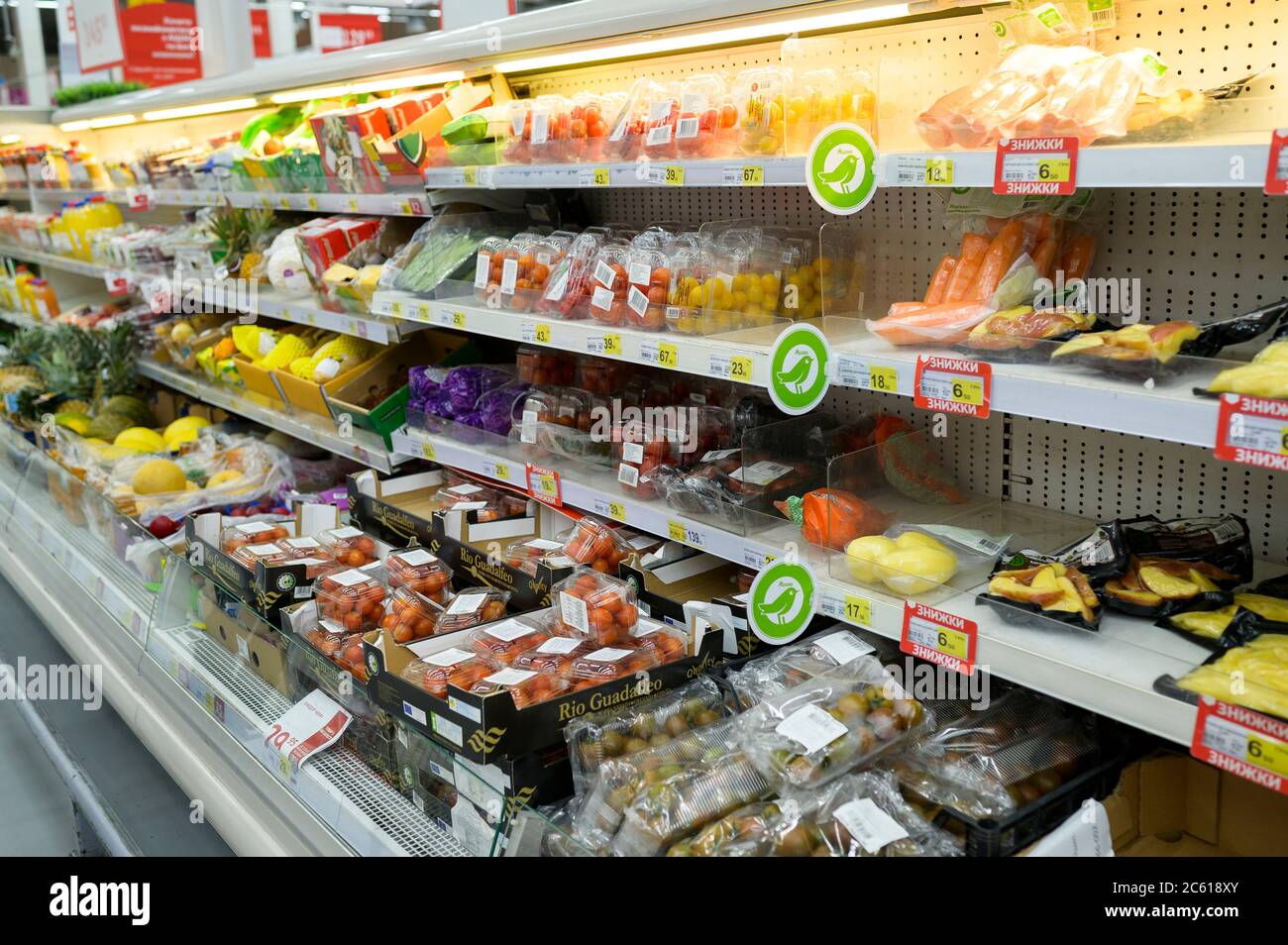 Obst und Gemüse in Verpackungen auf den Regalen des Supermarkts Stockfoto