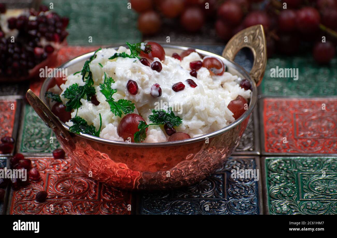 Südindischer Yougurt-Reis mit Trauben und Granatapfel in traditioneller Servierschüssel Stockfoto