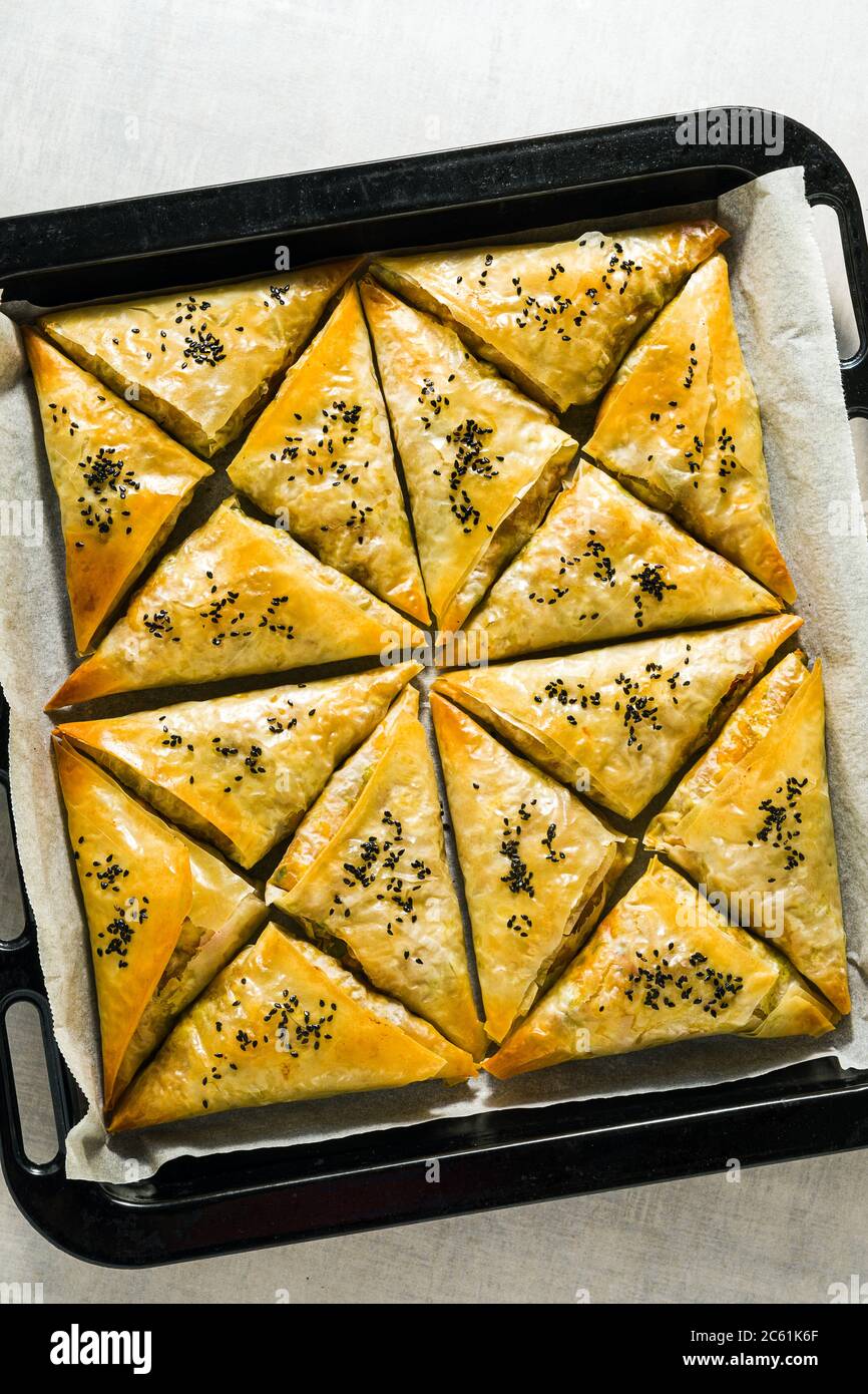 Gebacken im Ofen indischen Samosa mit Phyllo mit würzigen Kartoffeln und Gemüse mit schwarzen Sesam. Street traditionellen Fast Food Stockfoto