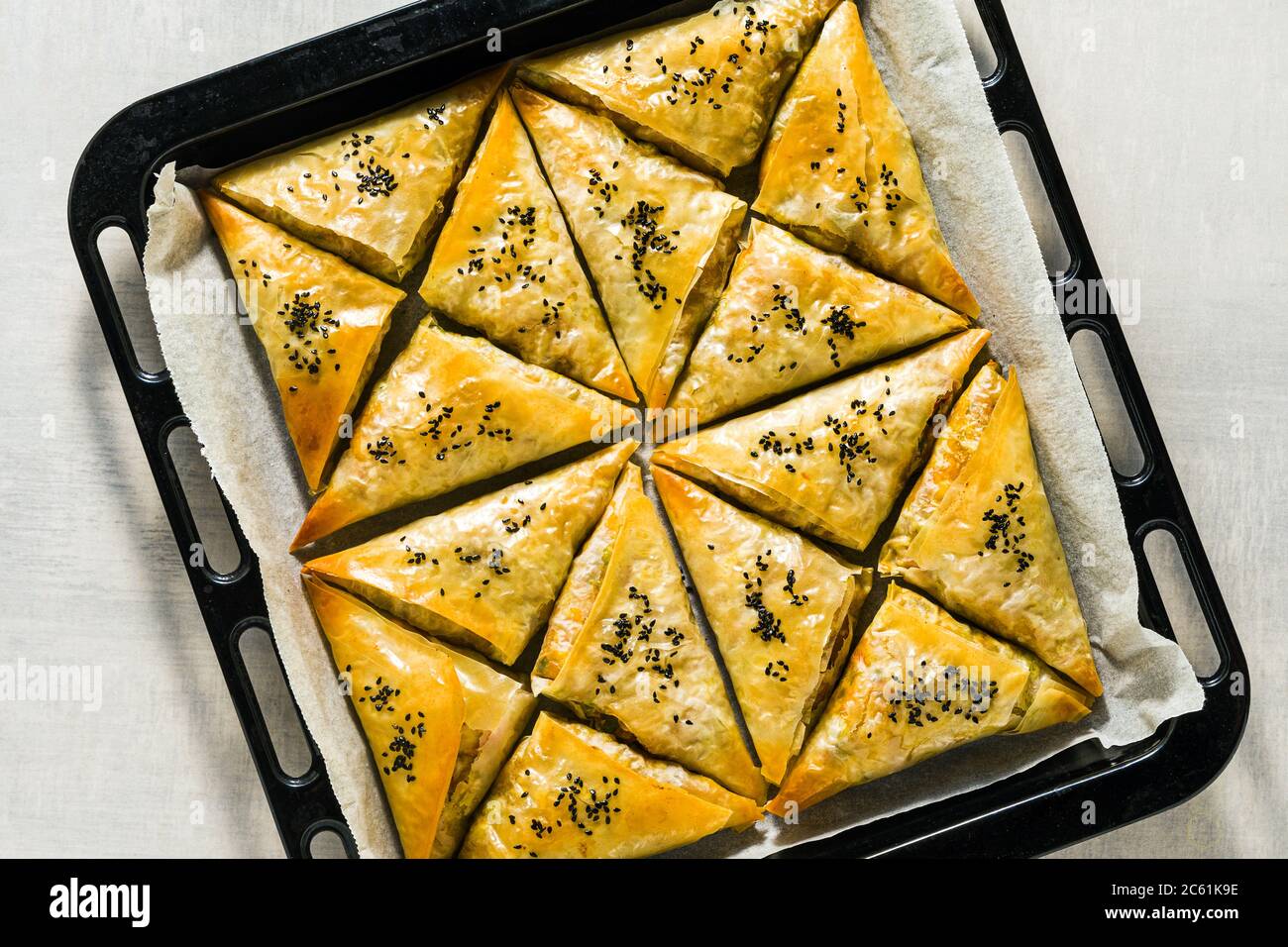 Gebacken im Ofen indischen Samosa mit Phyllo mit würzigen Kartoffeln und Gemüse mit schwarzen Sesam. Street traditionellen Fast Food Stockfoto