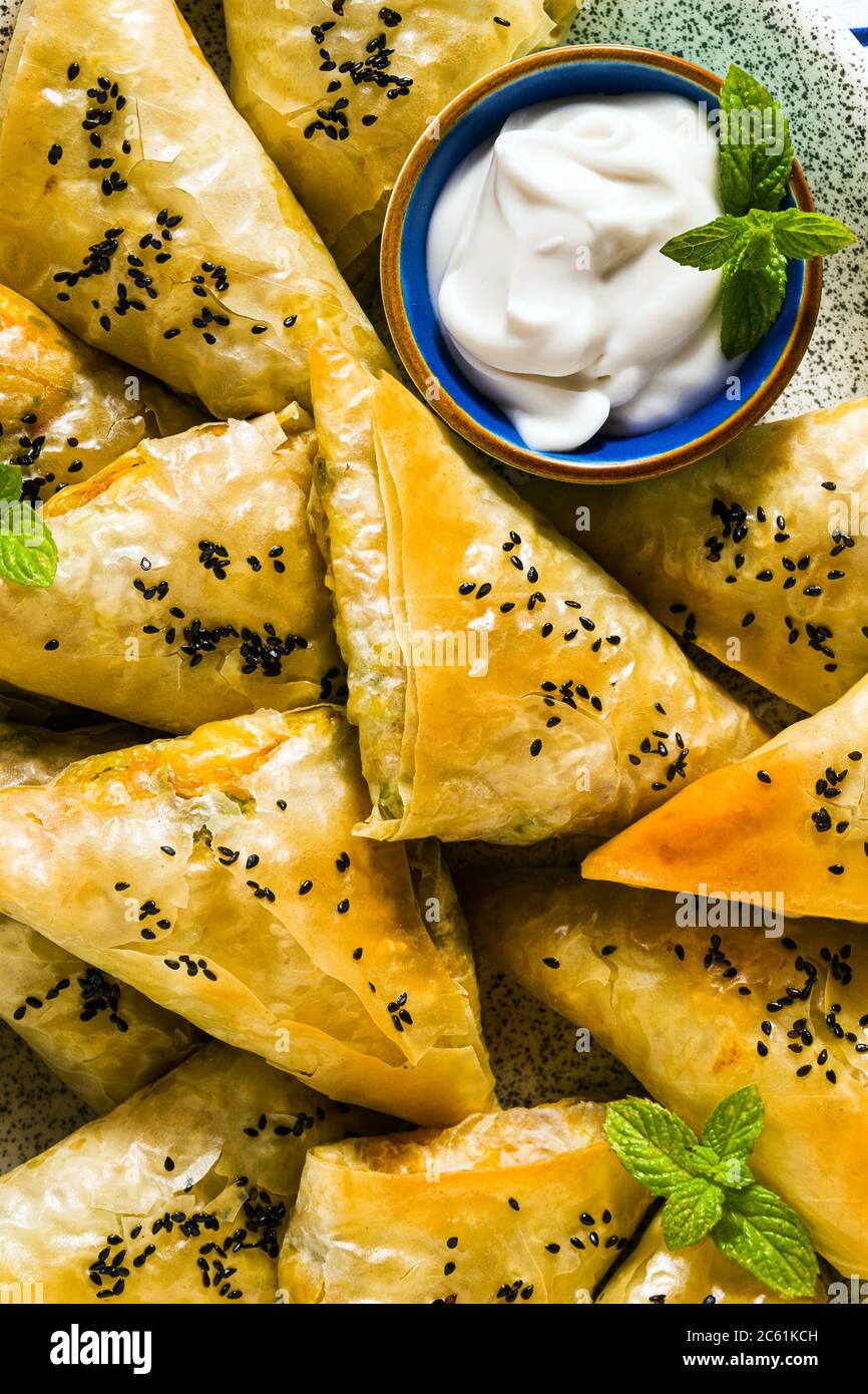 indische Samosa mit Phyllo mit würzigen Kartoffeln und Gemüse, serviert mit Joghurt, Minze und Zitrone. Nahaufnahme für die Werbung Stockfoto