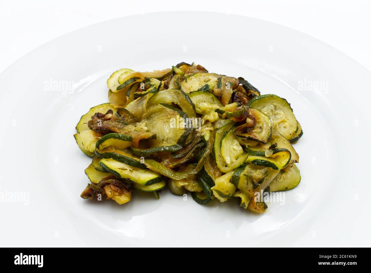 Gekochte Zucchini auf weißem Gericht isoliert auf weißem Hintergrund. Stockfoto