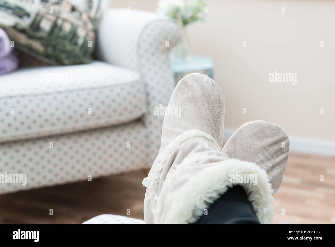 Bild Frauen Füße in gemütlichen Hausschuhen entspannen während zu Hause bleiben während Lock-down Stockfoto