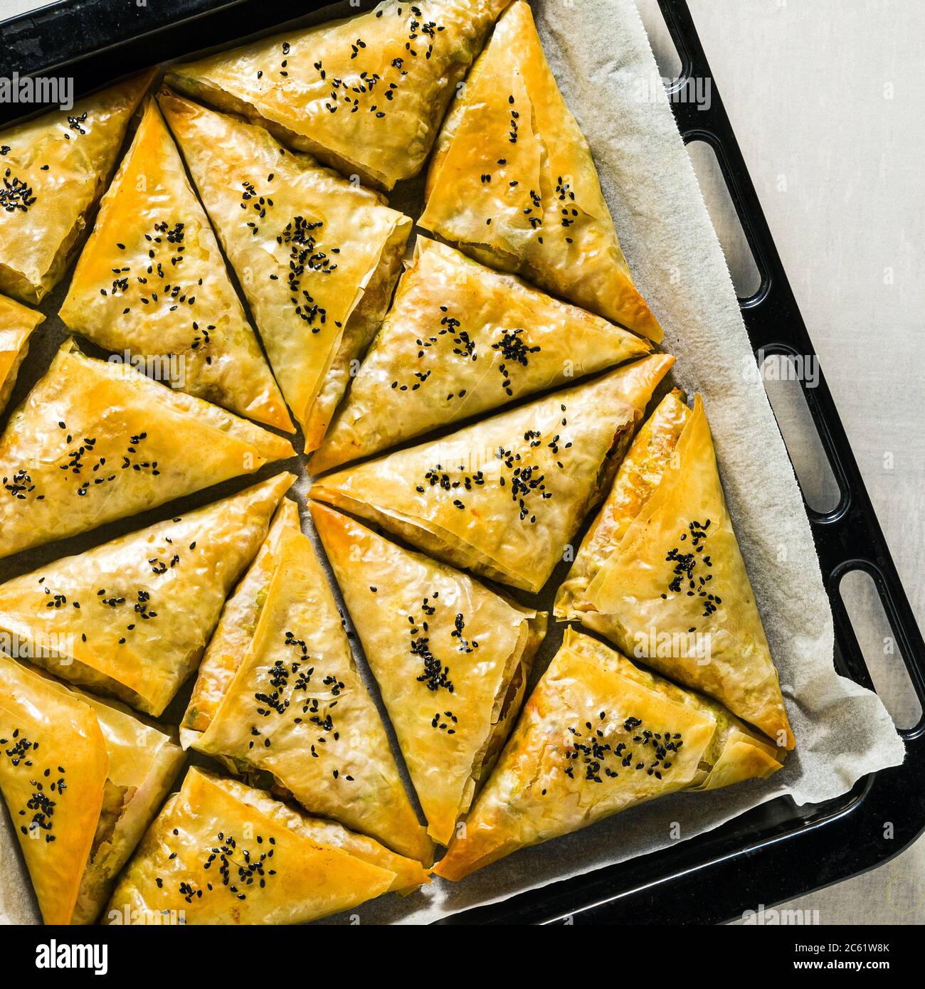 Gebacken im Ofen indischen Samosa mit Phyllo mit würzigen Kartoffeln und Gemüse mit schwarzen Sesam. Street traditionellen Fast Food Stockfoto