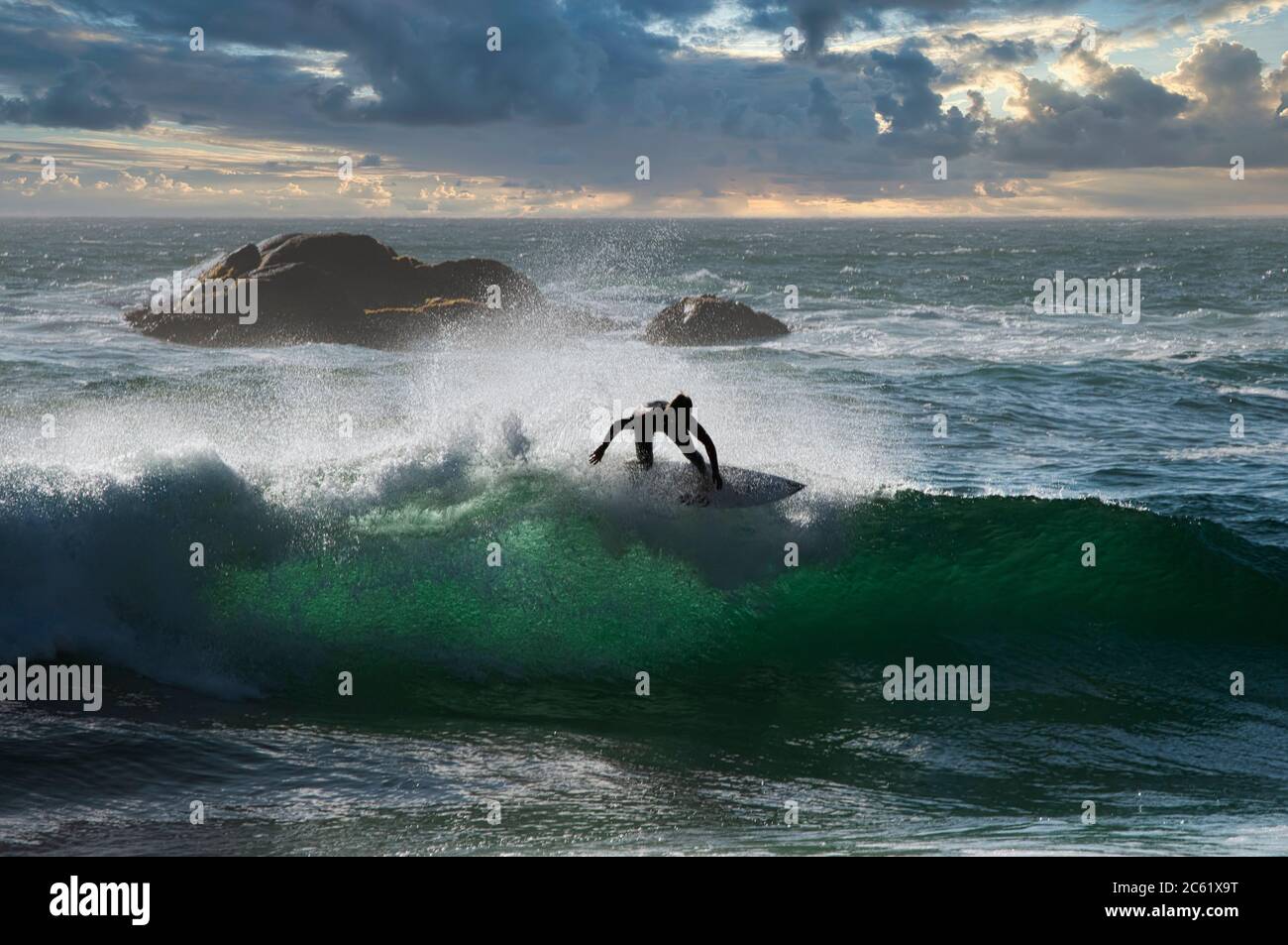 Surfer auf dem Kamm der Welle, Blick vom Strand Reñaca, Zentralküste von Chile. Im Hintergrund ein Schiff, das im Hafen von Valparaiso ankommt Stockfoto